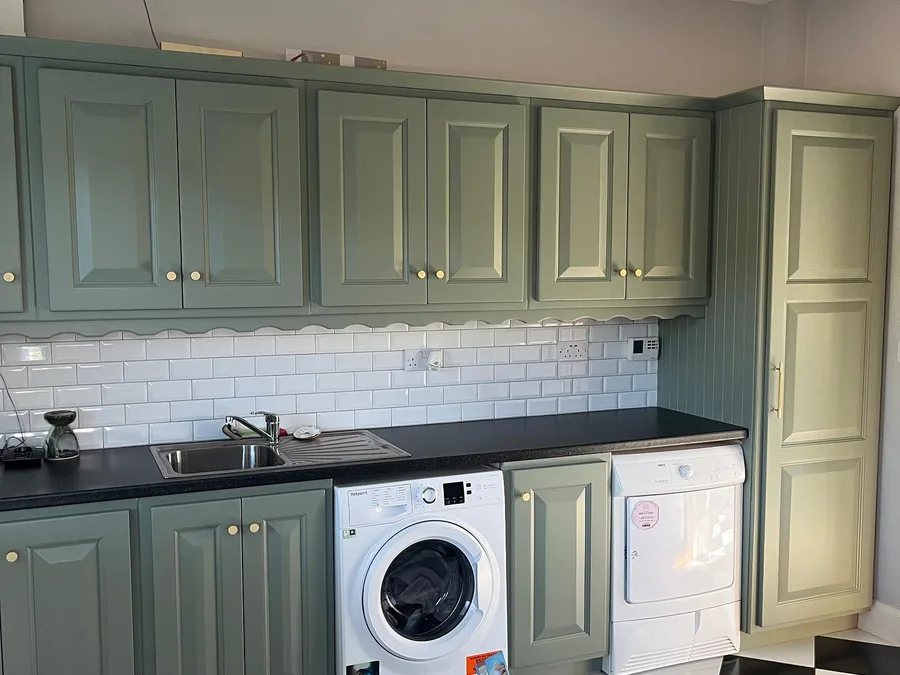 The same kitchen after respraying in Farrow and Ball Cardroom Green, with the handles and knobs replaced