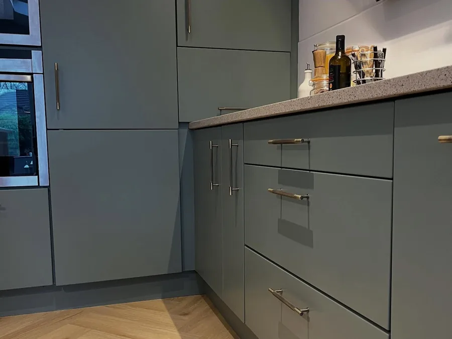 Kitchen units resprayed in a soft khaki green with brushed handles