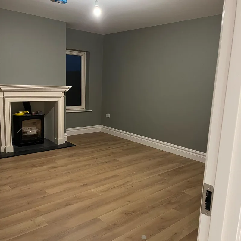A freshly painted room in a new build with panelled doors and oak flooring