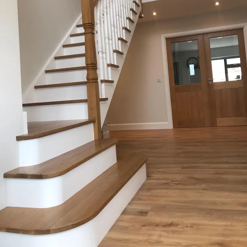 A staircase sprayed white with oak treads and handrail
