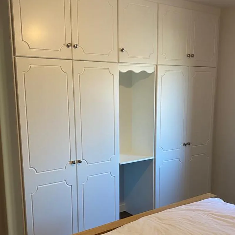 Built-in bedroom wardrobes resprayed in a soft white